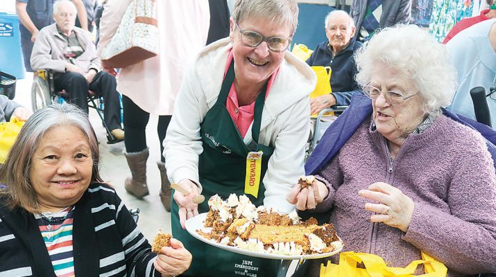 Steward Rosemary Bentley passes around the winning carrot cake for visitors Catherine Pearce and Edna Todd to take the taste test.